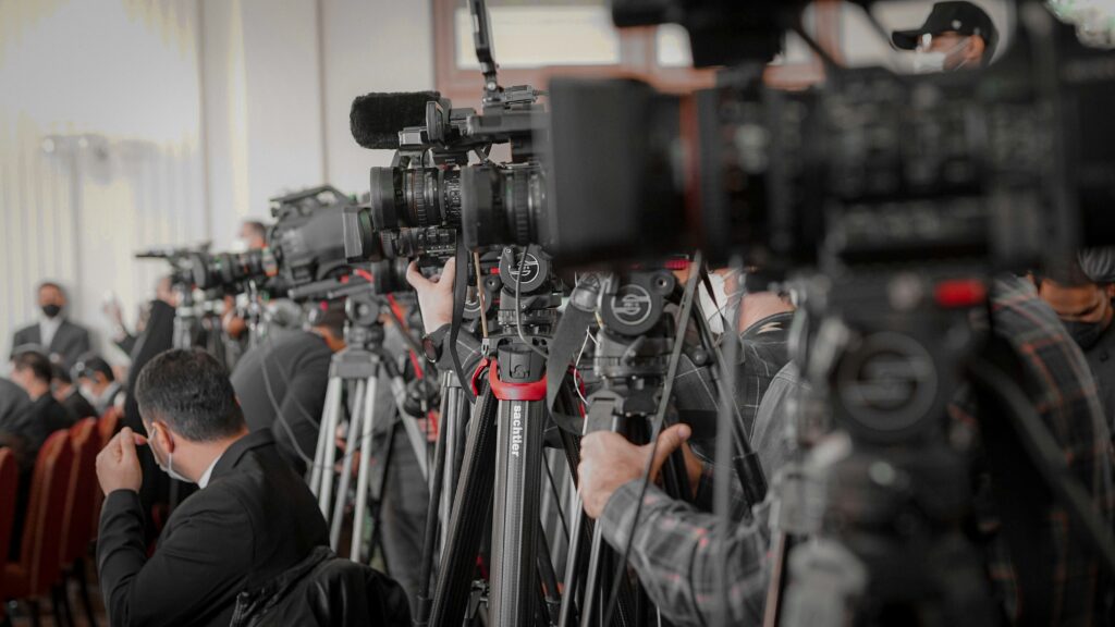 Media cameras and journalists covering a press conference – symbolizing limited coverage of India’s Coal Allocation Scam (Coalgate).