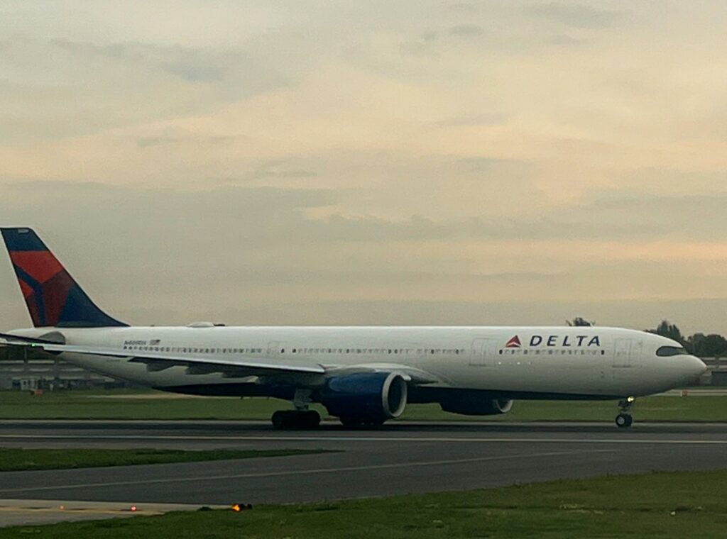 A Delta Airlines aircraft taxiing on the runway during sunset with cloudy skies in the background.-Delta Jets Collide at LaGuardia