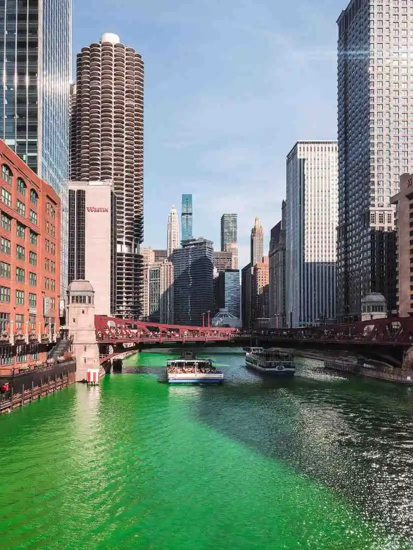 City skyline with river and skyscrapers illuminated in green for St. Patrick’s Day celebration